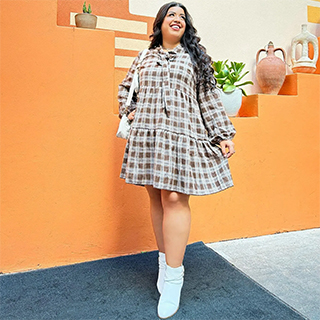 A female wearing a cute and affordable long sleeve checkered dress and white booties from a dd's store