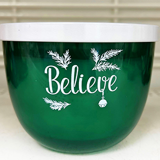 An image displaying pretty and luxurious green Christmas candle called Believe from a dd's store
