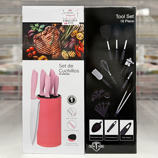 A boxed pink-handled 6‑piece knife set sits beside a black Simply Better 18‑piece kitchen tool set, both displayed on a store shelf.